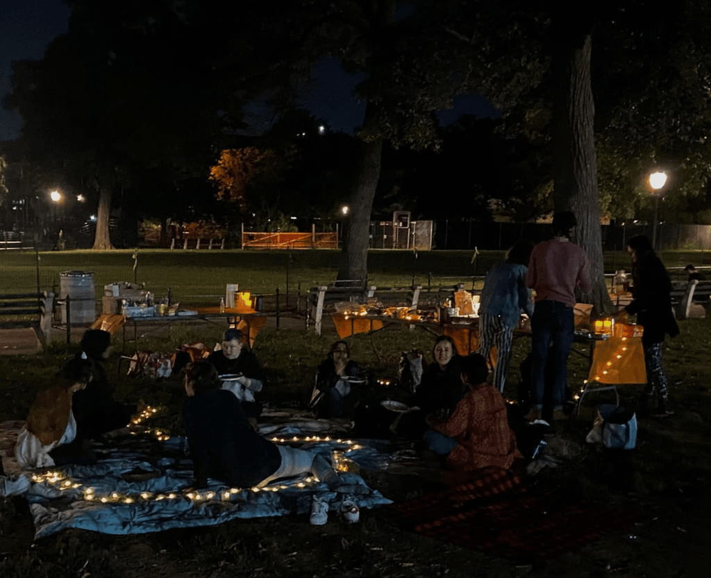 dark photo of a nighttime park potluck with some mutual aid organizer friends